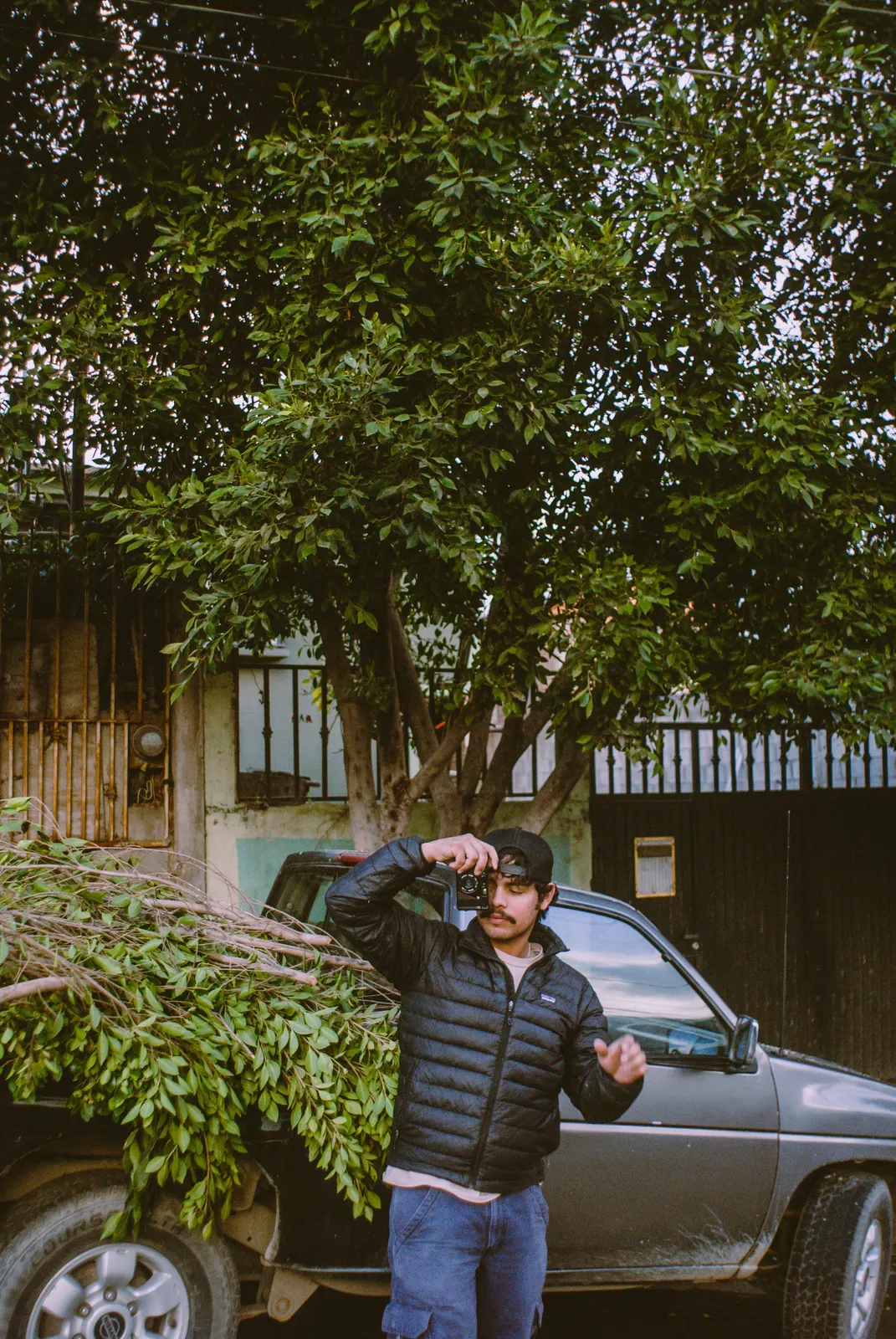 A tradesman in a cap standing by his pickup truck
